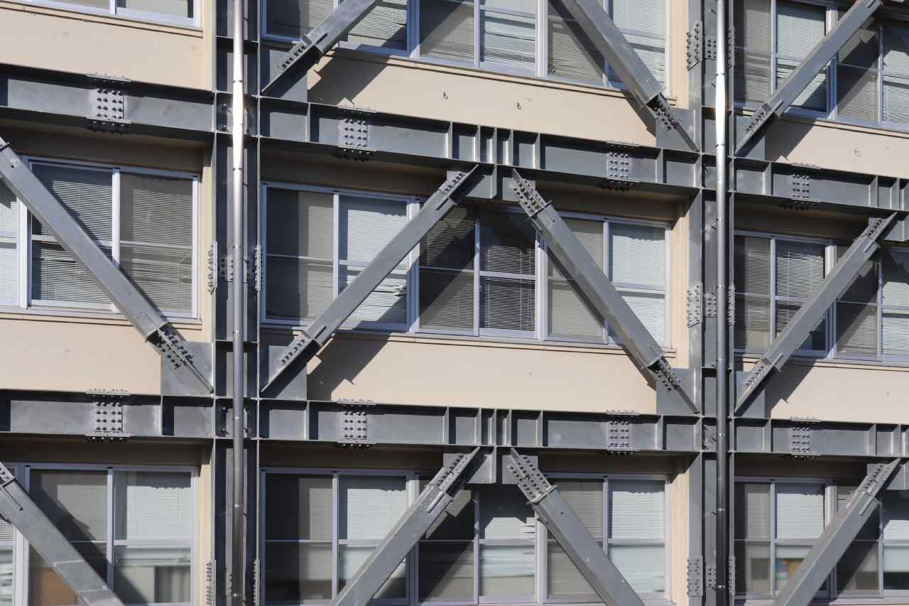  İnşaat aşamasındaki çok katlı bir binanın iskeleti, metal iskelelerle çevrili.